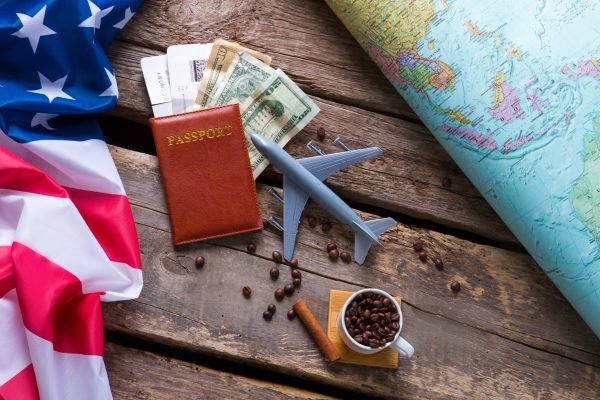 Passport near USA flag. Dollars and coffee beans. Take a trip to America. Freedom of law-abiding citizen.
